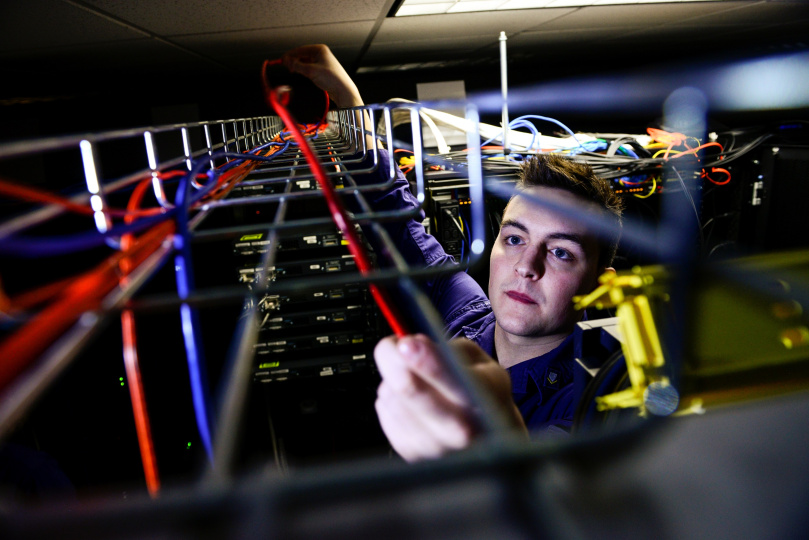 Person running cables in a server room