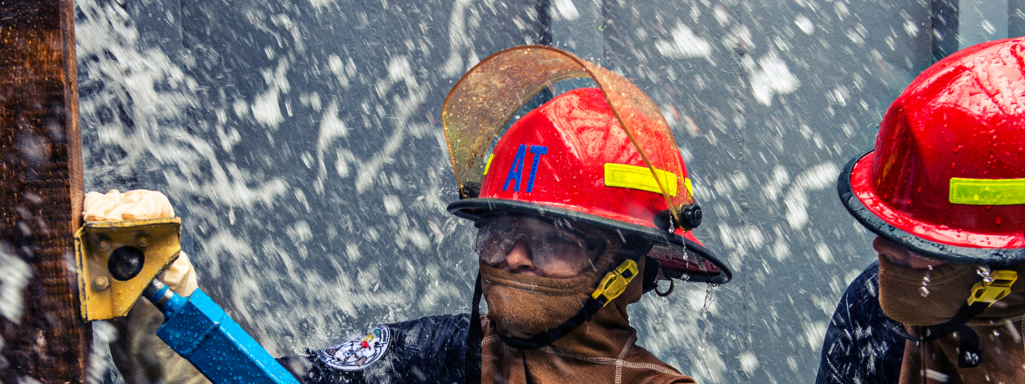 Two Damage Controlmen working in stormy conditions